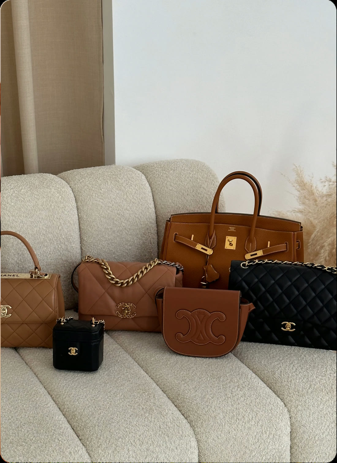 Designer handbags on a cream sofa